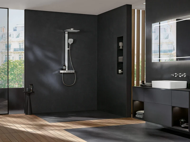Une robinetterie de douche Infinity Showers dans une salle de bains noire Une robinetterie de douche Infinity Showers dans une salle de bains aux murs noirs et au sol en bois.