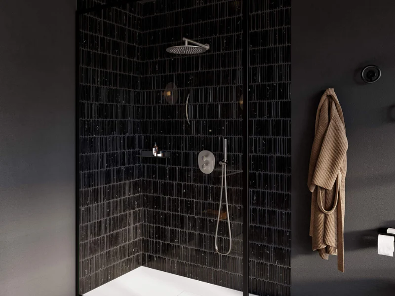 Un robinetterie de douche Antao dans une douche moderne Une douche à l’italienne moderne avec paroi en verre, des robinetteries en acier inoxydable de la collection Antao sur un carrelage noir Metro.