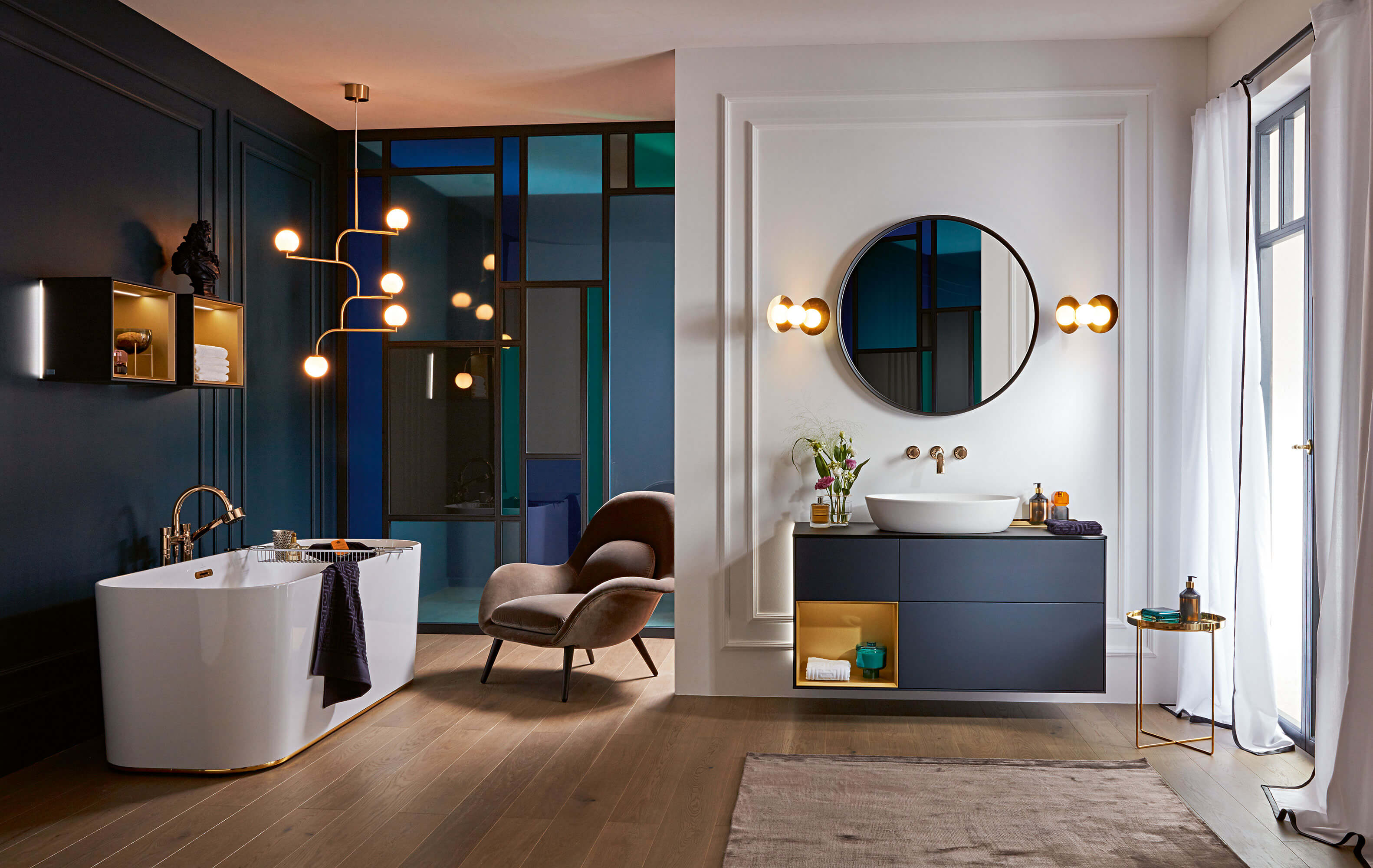 Une baignoire Finion dans une salle de bains classique en bleu foncé Une baignoire Finion dans une salle de bains classique avec des murs bleus et un sol en bois.