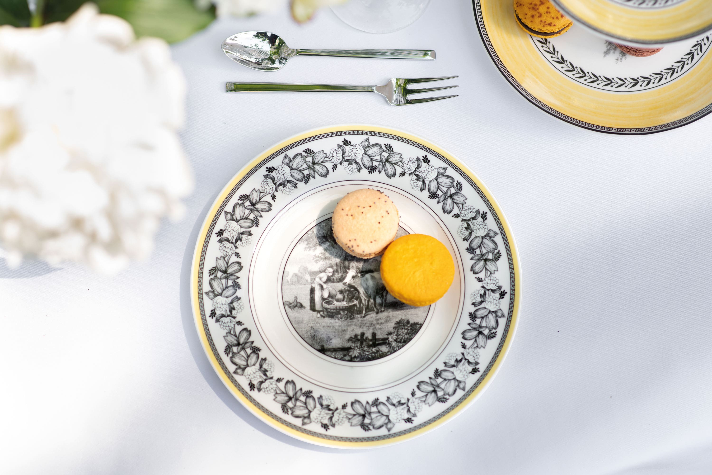 Une assiette pour le petit-déjeuner Audun de Villeroy & Boch avec des macarons jaunes Une élégante décoration de table avec une assiette pour le petit-déjeuner décorée de la collection Audun et deux macarons.